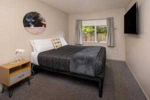 Un dormitorio con una cama grande y una ventana en Ohakune TOP 10 Holiday Park, en Ohakune