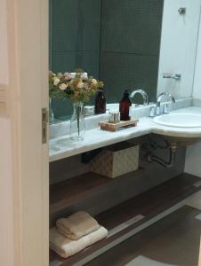 a bathroom with a sink and a vase of flowers at HERMOSO MONOAMBIENTE A POCAS CUADRAS DEL RIO! in Rosario