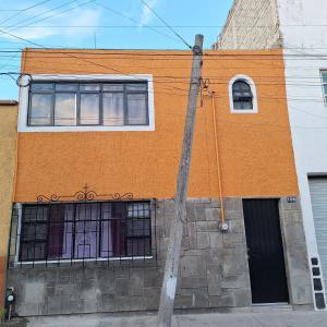un edificio naranja con ventanas en una calle en Hospedaje Guadalajara, en Guadalajara
