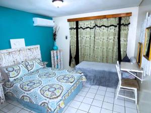 a bedroom with a bed and a table and a chair at Apartment Rustic Curaçao in Willemstad