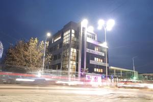 a building at night with traffic in front of it at Troci Hotel in Tirana