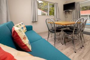 a living room with a blue couch and a table at Ohakune TOP 10 Holiday Park in Ohakune