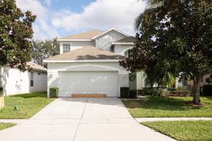 une maison blanche avec un garage dans l'établissement Windsor Hills Resort 6 Bedroom Private Pool & Spa 2 Miles to Disney A Villa Can See Disney Fireworks Every Night, à Kissimmee