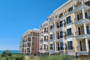 een groot gebouw met de oceaan op de achtergrond bij Exklusives Refugium am Meer in Sveti Vlas