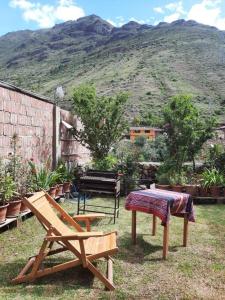 einen Hinterhof mit einem Tisch und einer Bank und einem Berg in der Unterkunft Cozy private home overlooking the Vilcanota river in Pisac