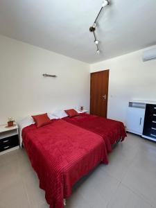 1 dormitorio con 1 cama grande de color rojo con manta roja en Casa de Odoya, en Caucaia