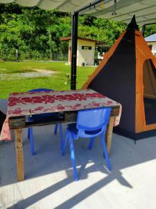stół piknikowy z namiotem w tle w obiekcie Camping TENUI w mieście Taputapuapea
