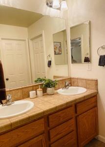 ein Badezimmer mit zwei Waschbecken und einem großen Spiegel in der Unterkunft New remodel farmhouse style w/ 4bedrooms +3 baths in Elk Grove