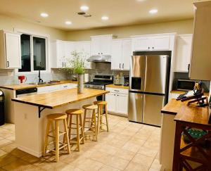 cocina con armarios blancos y nevera de acero inoxidable en New remodel farmhouse style w/ 4bedrooms +3 baths en Elk Grove