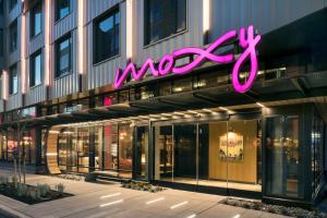 un'insegna al neon sul lato di un edificio di MOXY Seattle Downtown a Seattle