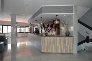 a man sitting at a counter in a lobby at BlumLuxury Apartment in San Bartolomé