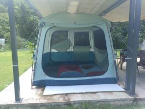 a tent with the door open in a field at Camping TENUI in Taputapuapea