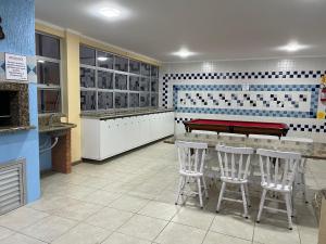 a restaurant with a bar with stools and a piano at apartamento na praia de Porto belo - SC in Porto Belo