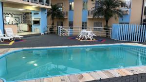 a swimming pool in front of a building at apartamento na praia de Porto belo - SC in Porto Belo