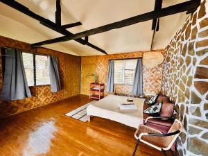 a living room with a couch and a stone wall at Playa del Fuego Camiguin Beach Hostel & Resort in Mambajao