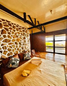 曼巴豪的住宿－Playa del Fuego Camiguin Beach Hostel & Resort，一间设有石墙和床的房间