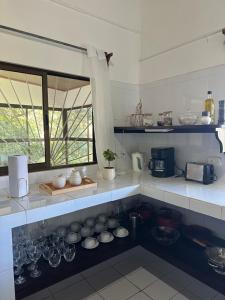 a kitchen with bowls and glasses on a counter at Carbell House in La Cruz