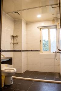 a bathroom with a toilet and a window at Boss's home in Dongshan