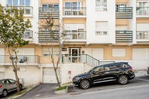 ein schwarzes Auto, das vor einem Gebäude geparkt ist in der Unterkunft Apartamento em Lisboa, perto de Sintra in Fontainhas