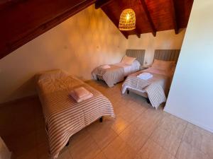 a room with three beds and a chandelier at Casa Estivariz Madryn in Puerto Madryn
