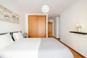 ein Schlafzimmer mit einem großen weißen Bett mit weißen Kissen in der Unterkunft Apartamento em Lisboa, perto de Sintra in Fontainhas
