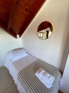 a small bedroom with a bed and a mirror at Casa Estivariz Madryn in Puerto Madryn