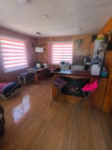 una camera con scrivania e due sedie rosa di Cabañas Sofi a Quillón