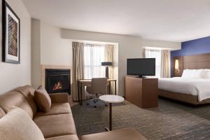 ein Hotelzimmer mit einem Bett und einem Kamin in der Unterkunft Residence Inn by Marriott Salinas Monterey in Salinas
