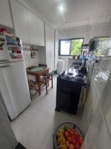 a kitchen with a refrigerator and a bowl of fruit at Apto Centro Bertioga (800 metros da praia) in Bertioga