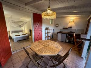 a room with a table and a kitchen with a bed at Gîte Ti Carbet - Vue mer in Grand-Bourg