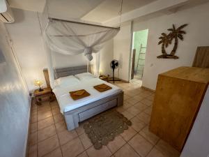 a bedroom with a white bed with a canopy at Gîte Ti Carbet - Vue mer in Grand-Bourg