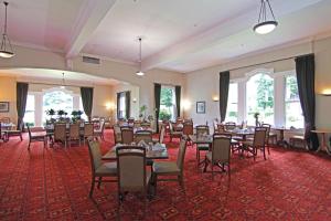 a banquet hall with tables and chairs and windows at Hanmer Springs Hotel in Hanmer Springs