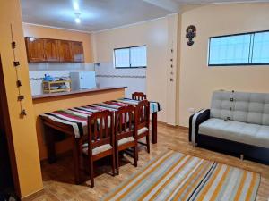 eine Küche mit einem Tisch, Stühlen und einem Sofa in der Unterkunft Cozy home with garden overlooking the Vilcanota river in Pisac