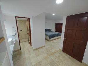 a bedroom with a bed and a door to a bathroom at Hotel Plaza Huatulco Bungalows in Santa Maria Huatulco