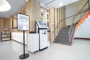 a ticket machine in a lobby with a staircase at Yung An Business Hotel in Dounan