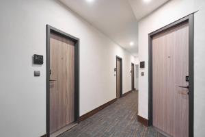 a row of elevators in a hallway with wooden doors at Yung An Business Hotel in Dounan