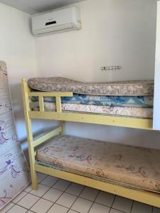 2 łóżka piętrowe w pokoju z wentylatorem w obiekcie Itamaracá w mieście Itamaracá