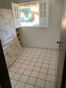a bathroom with a window and a tiled floor at Itamaracá in Itamaracá