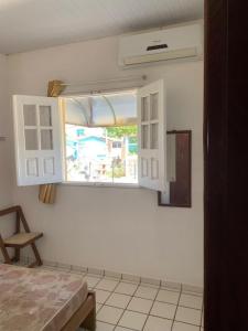 a bedroom with a window and a white wall at Itamaracá in Itamaracá