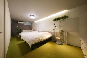 a bedroom with a large white bed in it at Holiday House Green Garden in Gujo