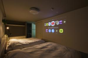 um quarto com duas camas e uma parede com aplicativos em Holiday House Green Garden em Gujo