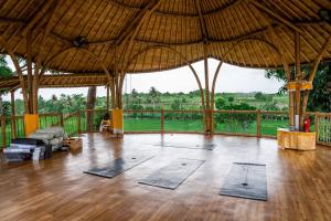 Habitación grande con esterillas de yoga en el suelo de madera. en Shanti Boutique Retreat en Tanah Lot