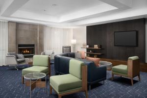 a living room with a couch and chairs and a tv at Courtyard by Marriott Lakeland in Lakeland