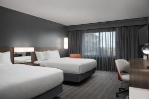 a hotel room with two beds and a desk at Courtyard by Marriott Lakeland in Lakeland