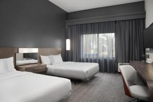 a hotel room with two beds and a window at Courtyard by Marriott Lakeland in Lakeland