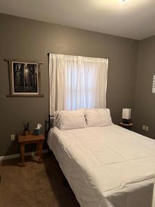 - une chambre avec un lit blanc et une fenêtre dans l'établissement Driftwood Cottage with Hot Tub on Lake Cumberland, à Russell Springs