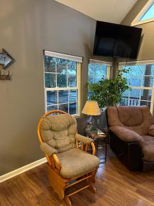 - un salon avec une chaise et un canapé dans l'établissement Driftwood Cottage with Hot Tub on Lake Cumberland, à Russell Springs