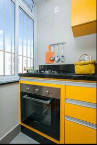 Il comprend une cuisine équipée d'une cuisinière et d'un four jaune. dans l'établissement Boa Opção Asa Sul, à Brasilia