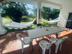 a patio with a table and chairs and hammocks at Villa cerca del Mar in Guanche