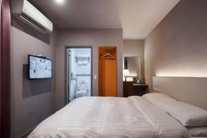a bedroom with a bed and a tv on a wall at Yung An Business Hotel in Dounan